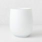 Handblown opaque white glass barrel vase with a modern curved silhouette, 9 inches tall.