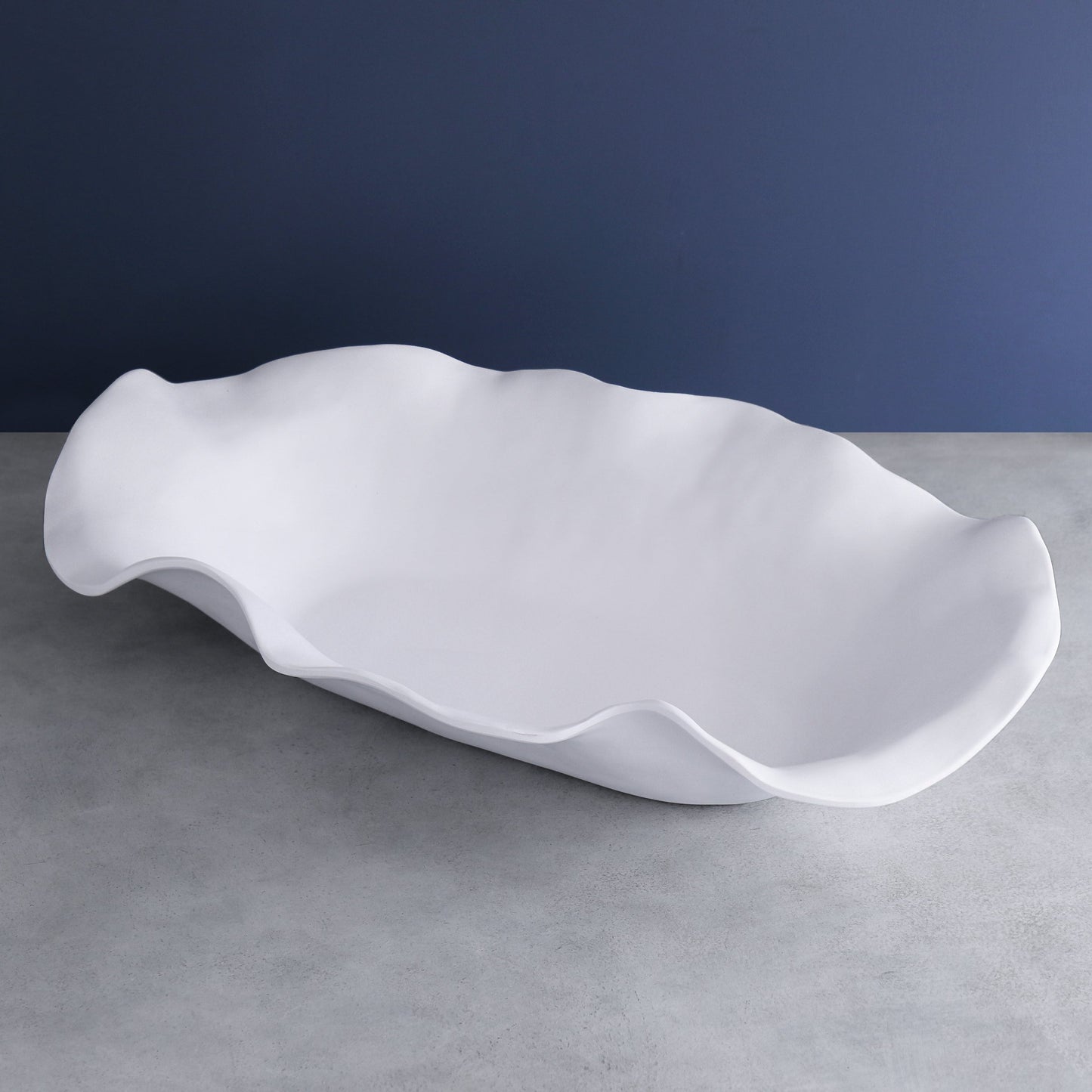 Large white melamine oval centerpiece with sculptural, wavy edges.
