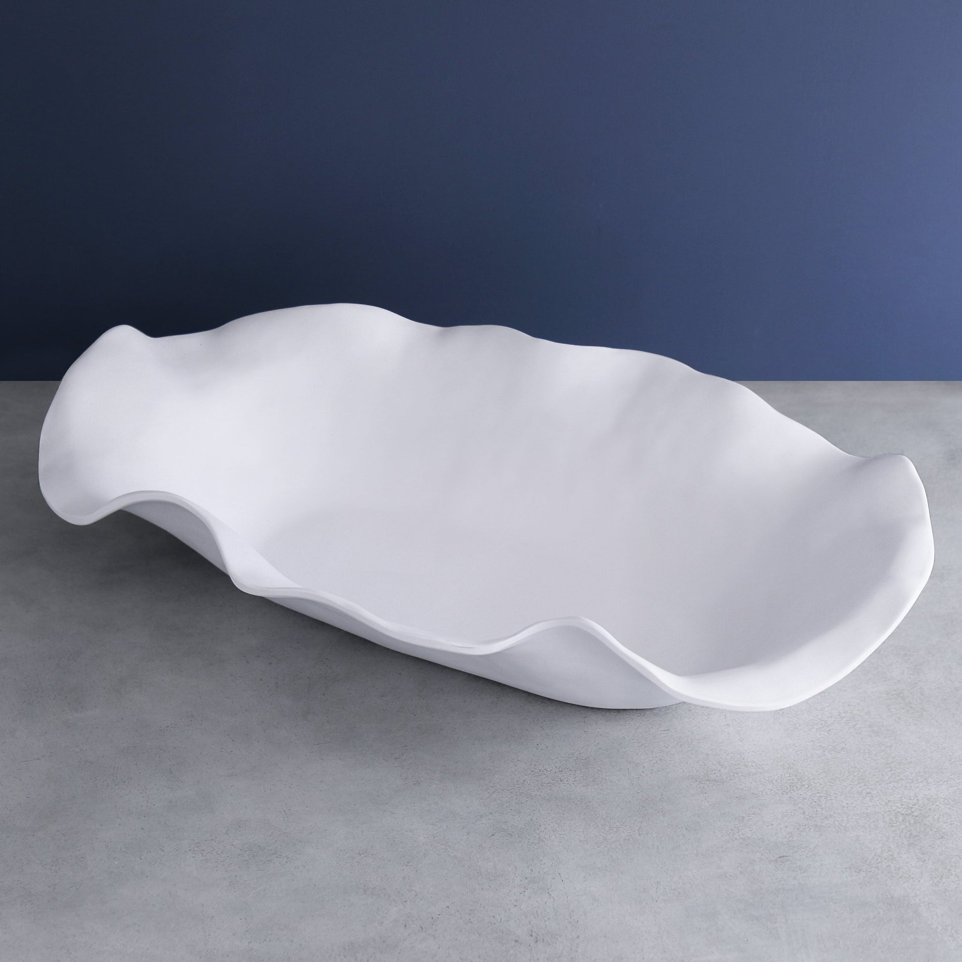 Large white melamine oval centerpiece with sculptural, wavy edges.
