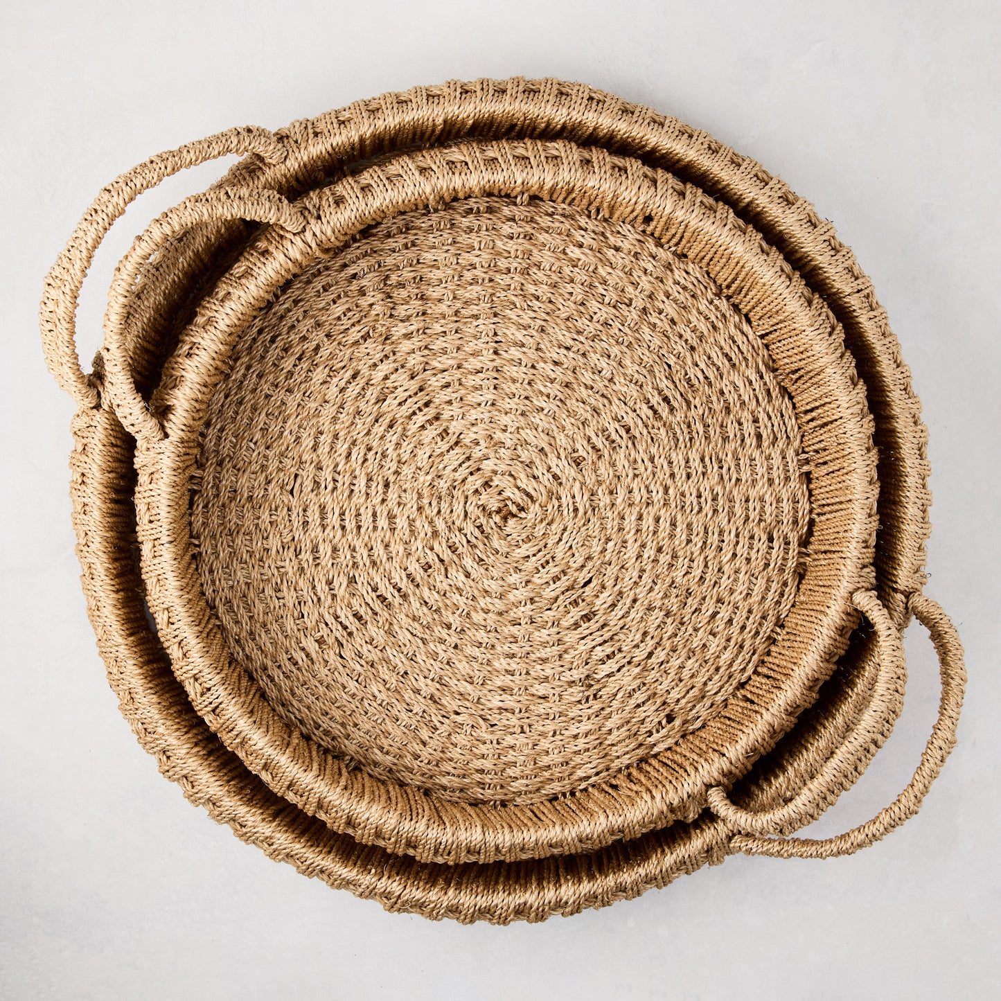 Large round woven abaca handled tray, natural brown, tightly woven texture, integrated handles.