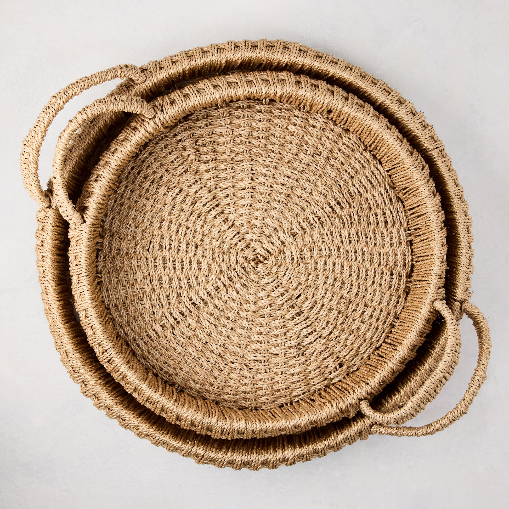 Large round woven abaca handled tray, natural brown, tightly woven texture, integrated handles.