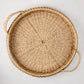 Large round woven abaca handled tray, natural brown, 20" diameter, with integrated handles.