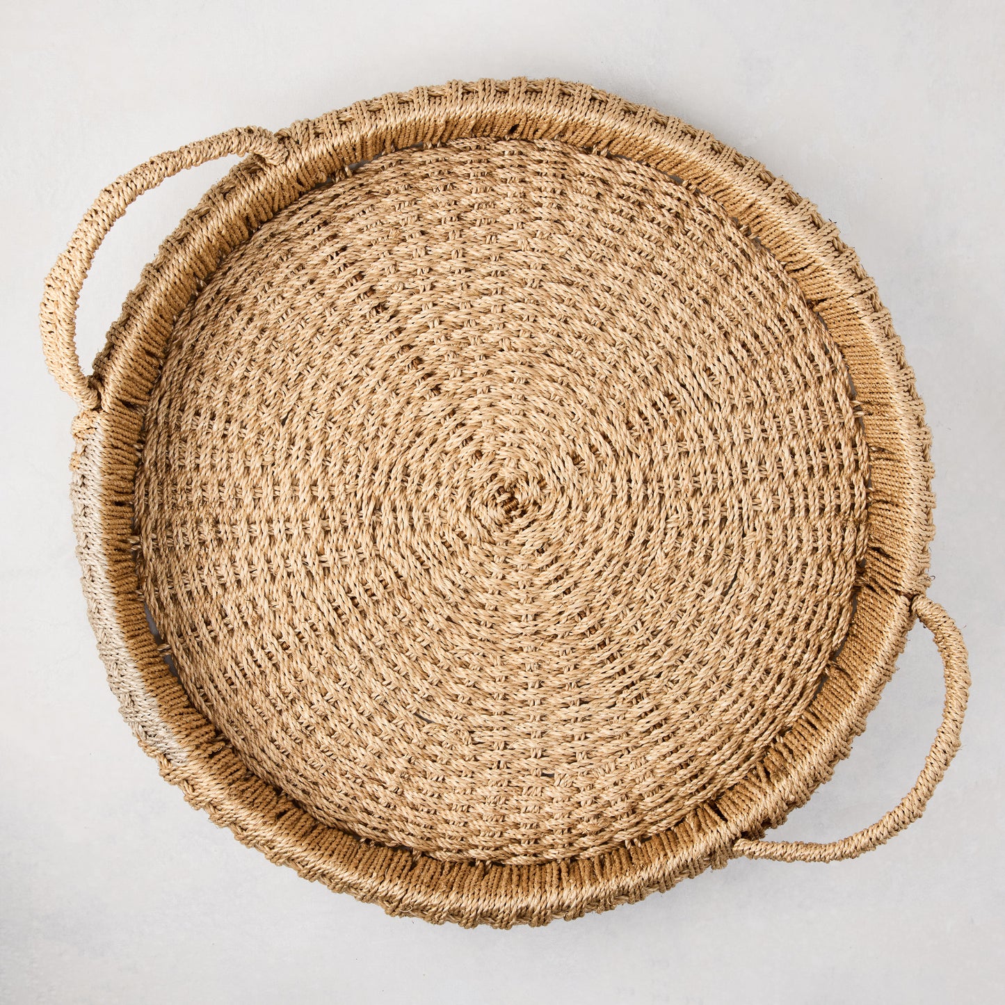 Large round woven abaca handled tray, natural brown, 20" diameter, with integrated handles.
