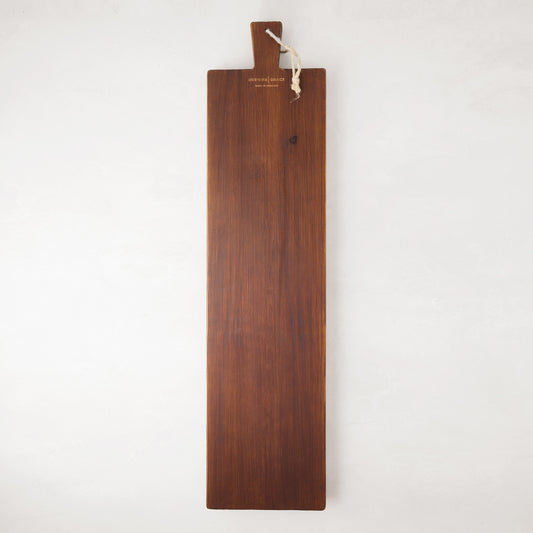 Long, dark brown European pine serving plank with a handle and rope for hanging.