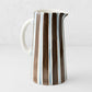 Large Italian ceramic pitcher with hand-painted navy and chocolate brown vertical stripes on a white glazed finish.