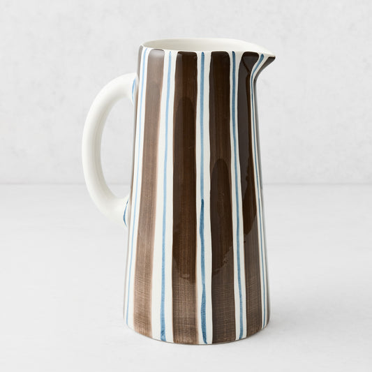 Large Italian ceramic pitcher with hand-painted navy and chocolate brown vertical stripes on a white glazed finish.