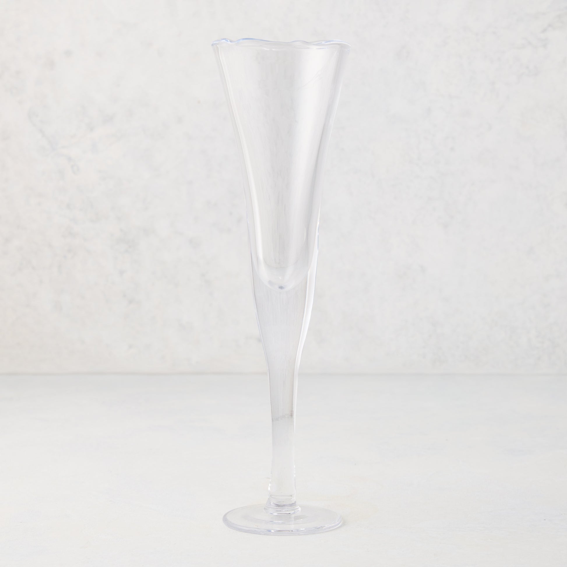 Clear, tall scissor-cut glass champagne flute with a rippled rim, 12 oz.