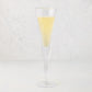 Clear, thick, air-blown glass champagne flute with a rippled rim, filled with sparkling yellow liquid.