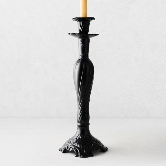 Large Tosca matte black ceramic candlestick with a twisted stem and ornate base, holding a cream taper candle.