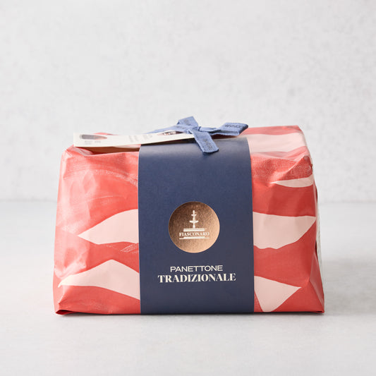 Large Fiasconaro Panettone wrapped in red and pink patterned paper with a blue band, gold logo, and ribbon tie.