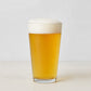 Clear, thick-walled Hudson Grace glass filled with golden beer and white foam.