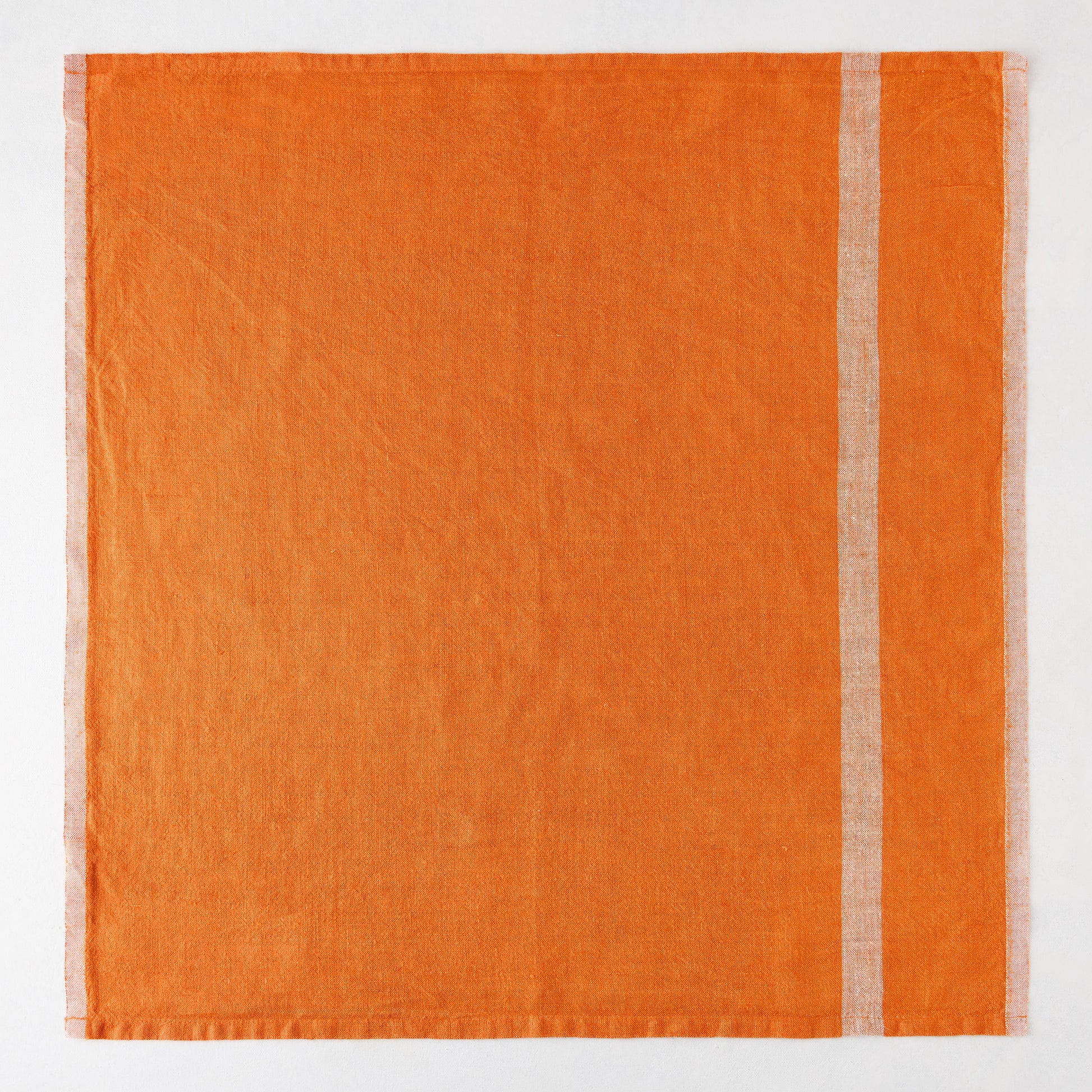Bright orange laundered linen napkin with paler vertical stripes.