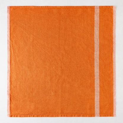 Bright orange laundered linen napkin with paler vertical stripes.