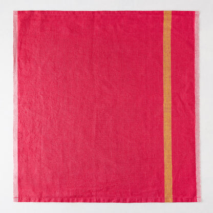 Laundered bright pink linen napkin with a single vertical gold stripe and paler striped edges.