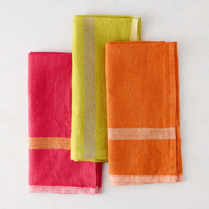 Laundered lime green, pink, and orange linen napkins with paler stripes.