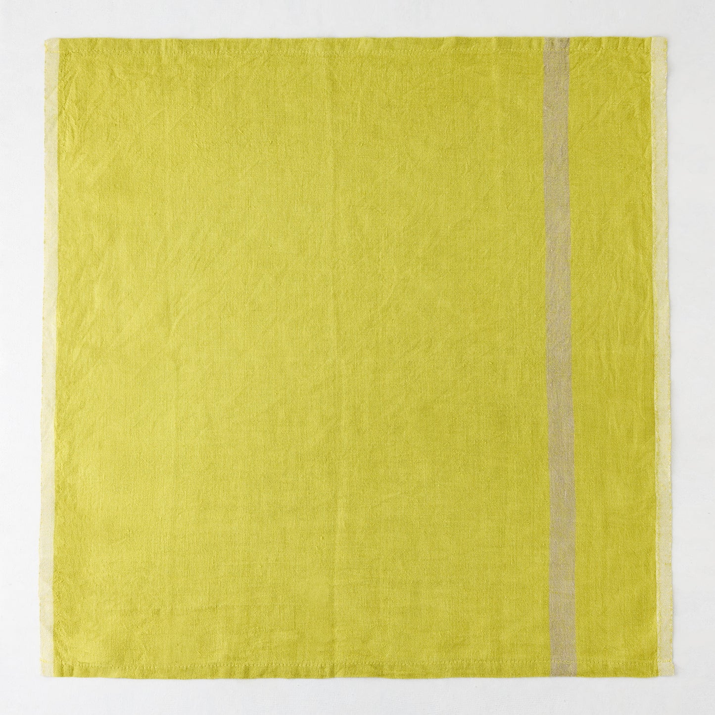 Laundered lime green linen napkin with a paler stripe on the right and a thin stripe on the left.