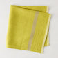 Folded Laundered Lime Green Linen Napkin with a paler vertical stripe, 22" square.