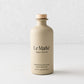 Le Marké olive oil in a matte beige ceramic bottle with a wooden cork stopper, 12.6 oz size.