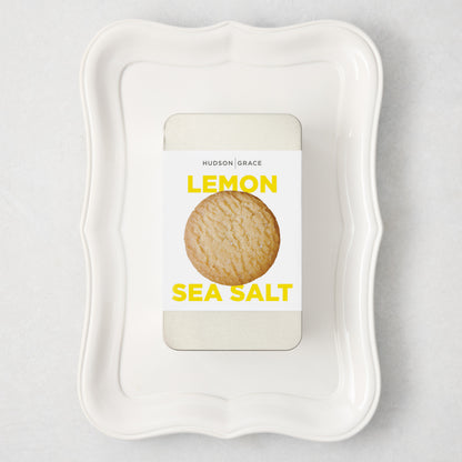 White rectangular Colette Platter with curved edges holding a silver tin of Hudson Grace Lemon Sea Salt cookies.