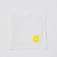 White linen cocktail napkin coaster with embroidered yellow lemon slice.