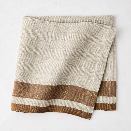 Lexington Tobacco Brown Stripe Border Napkin, linen-cotton blend, natural with brown stripes.