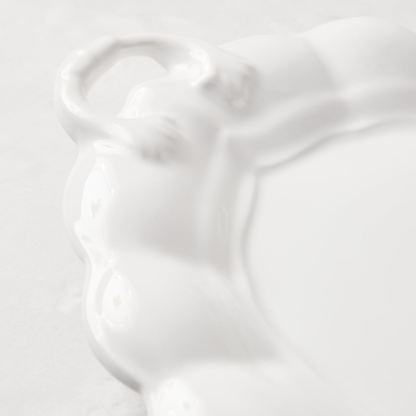 White ceramic oval serving platter with decorative handles and French detailing.