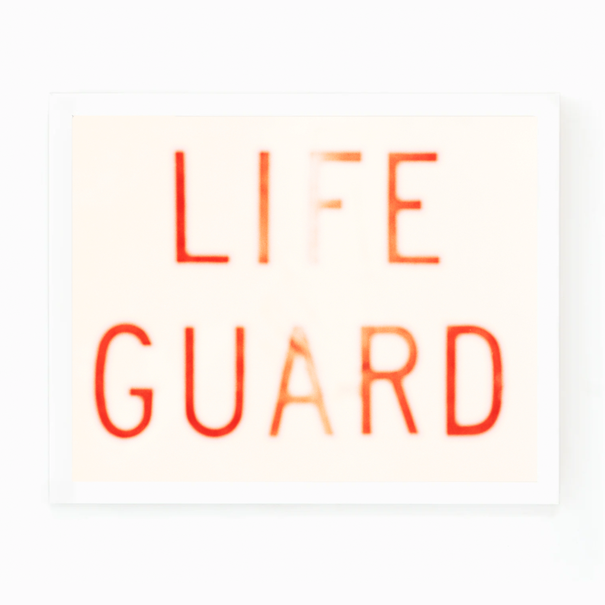 Matt Albiani's "Lifeguard" photograph: blurred red text on a light background in a white frame.