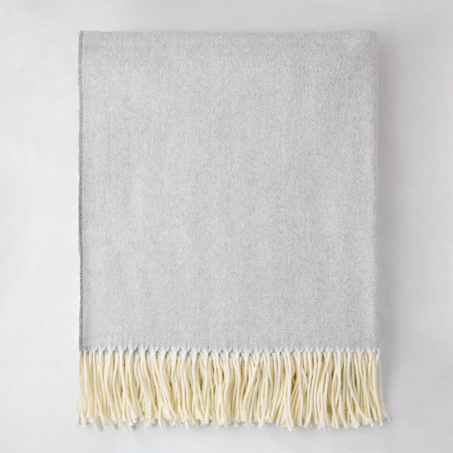 Light gray Italian herringbone throw blanket with cream fringe, 50% cotton, 50% soft acrylic.