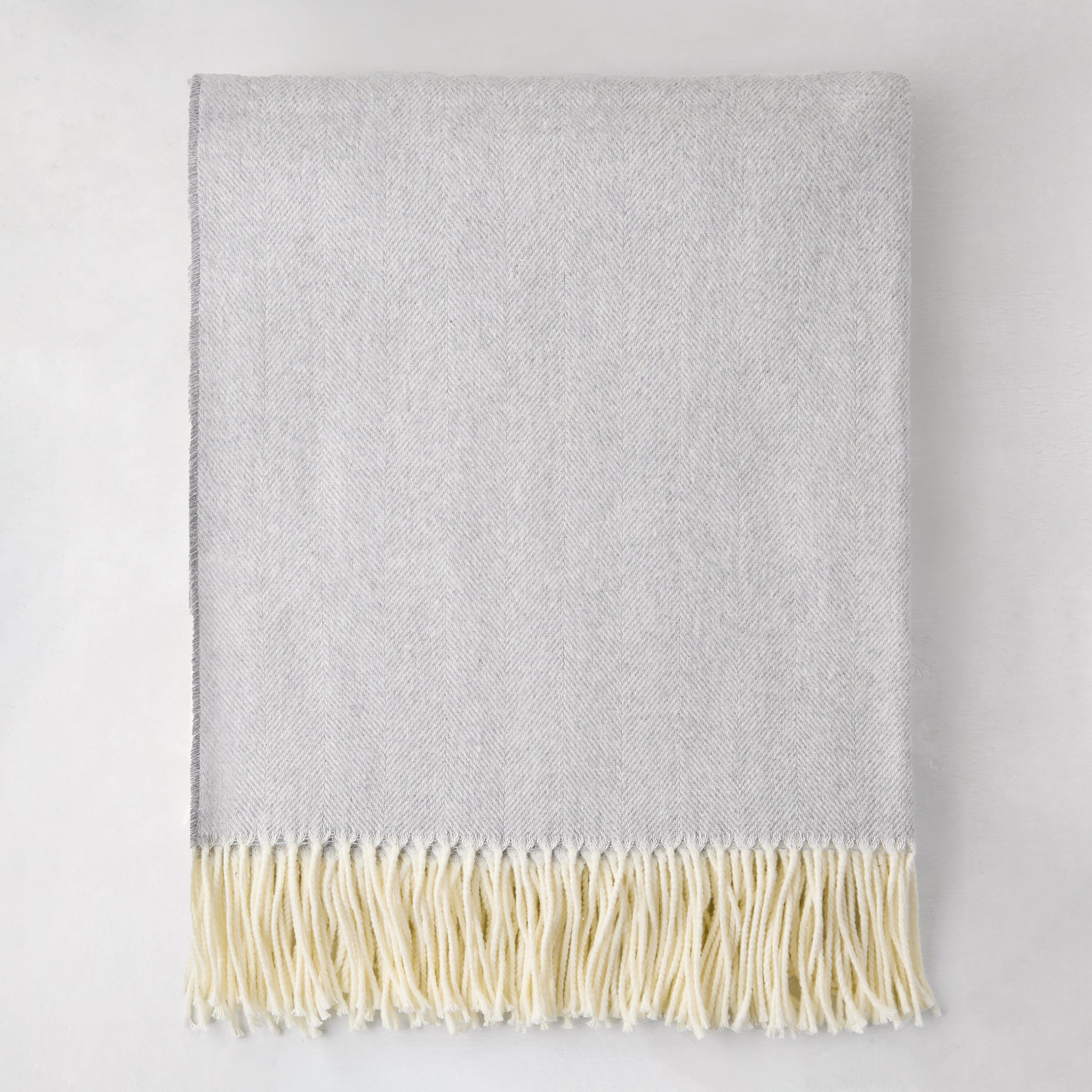 Light gray Italian herringbone throw blanket with cream fringe, 50% cotton, 50% soft acrylic.