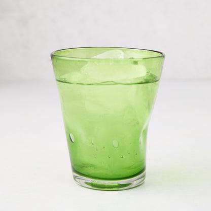 Light green Henri mouth-blown glass, 8 oz, with ice and water, showing unique imperfections and air bubbles.