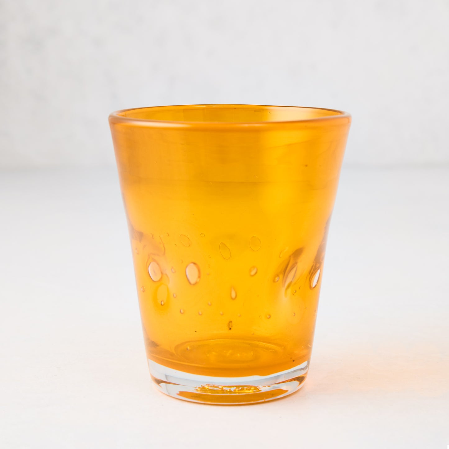 Light orange, mouth-blown Henri glass with unique imperfections and small air bubbles.