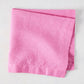 Lily HG Signature hand-dyed pink linen napkin, folded, 22-inch square.