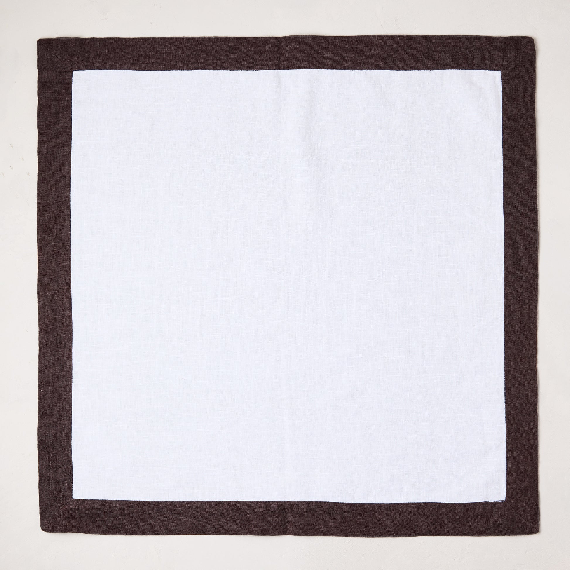 White linen napkin with a cocoa brown border, 22x22 inches.