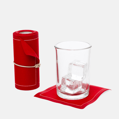 Roll of 50 Lipstick Red cotton tear-off cocktail napkins with a glass of ice on one napkin.