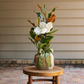 Live Magnolia Mini Gift Tree with glossy green leaves, a white bloom, and a burlap-wrapped base with a green ribbon.