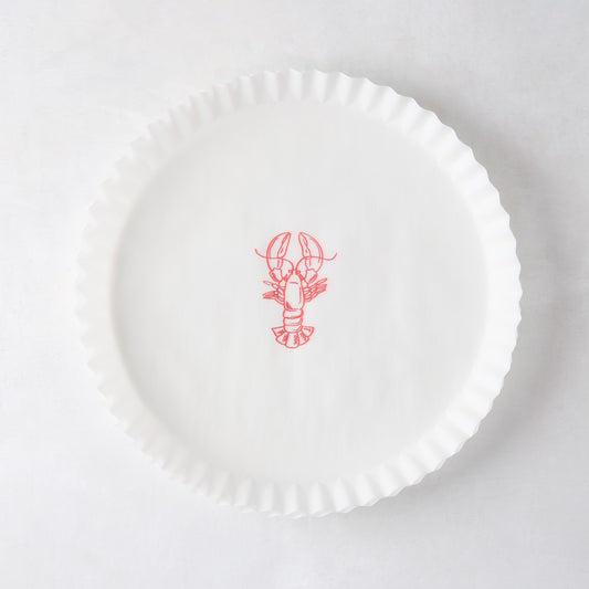 White round parchment liner with ruffled edges and a red lobster illustration in the center.