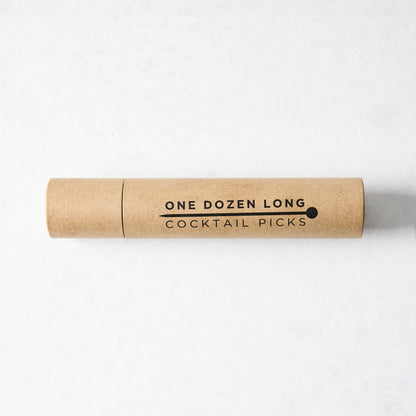 Kraft paper tube with "ONE DOZEN LONG COCKTAIL PICKS" in black text and a ball-top pick icon.