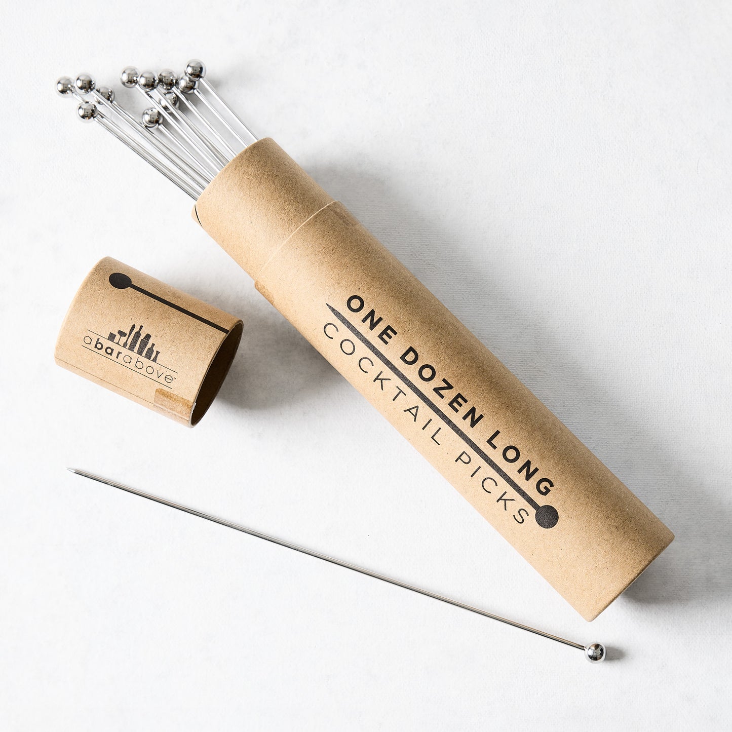 Set of 12 long 8" stainless steel cocktail picks with ball tops in a brown cardboard tube.