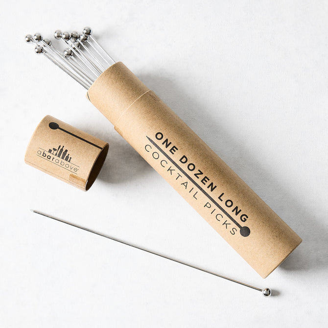 Set of 12 long 8" stainless steel cocktail picks with ball tops in a brown cardboard tube.