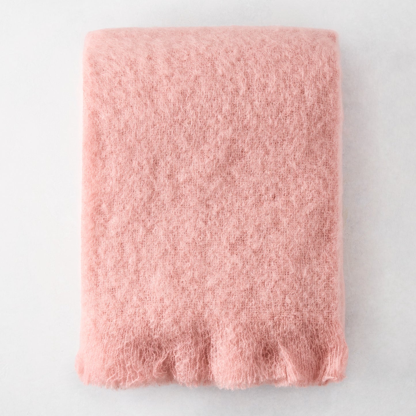 Folded Lotus Pale Pink Solid Mohair Throw Blanket, 72"L x 51"W, with fringed ends.