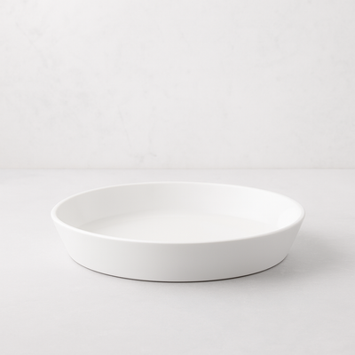 White, round Luce Small Ceramic Serving Dish, 11.5" diameter, with a minimalistic design.