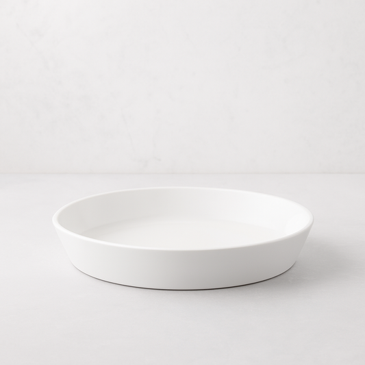 White, round Luce Small Ceramic Serving Dish, 11.5" diameter, with a minimalistic design.