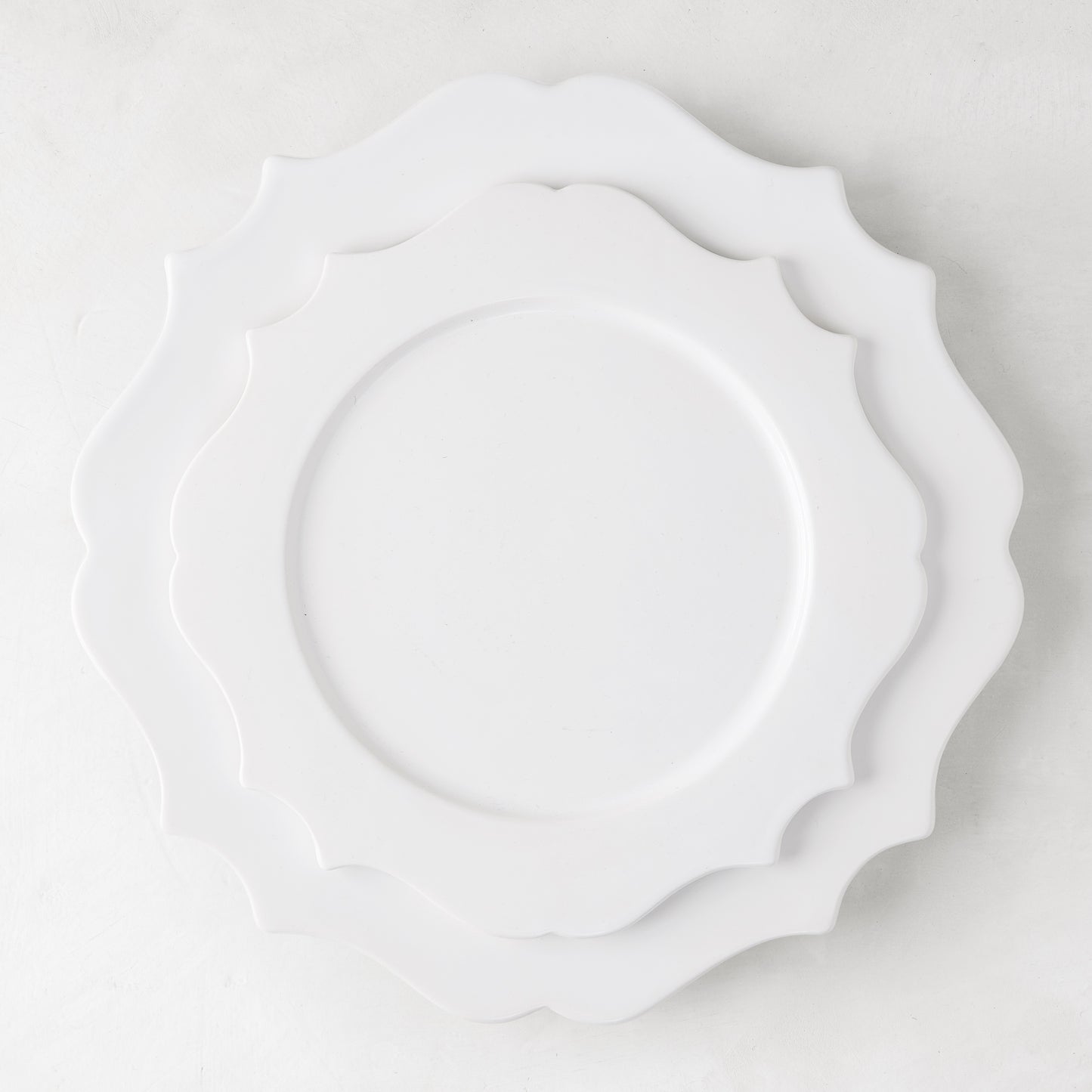 White ceramic Lungarno dinner plate with sculptural, scalloped edges, 11" diameter.