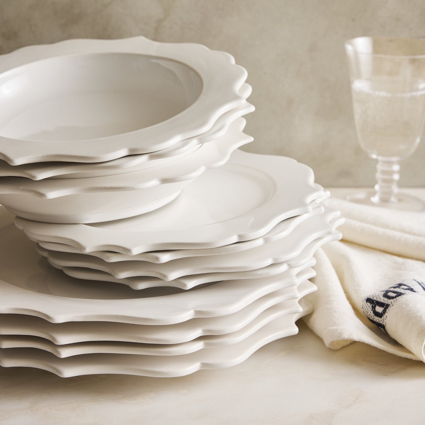 Stack of white ceramic Lungarno salad plates with sculptural scalloped edges, 9-inch diameter, made in Italy.