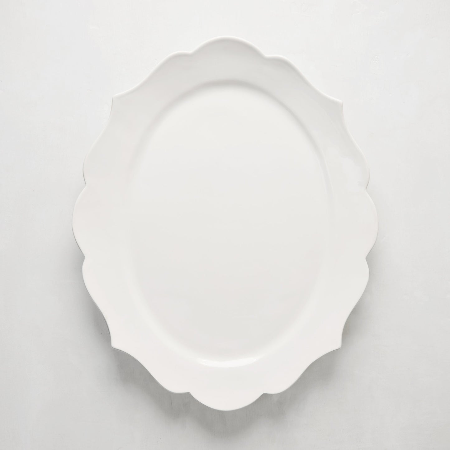 White ceramic Lungarno serving platter with sculptural, scalloped edges.