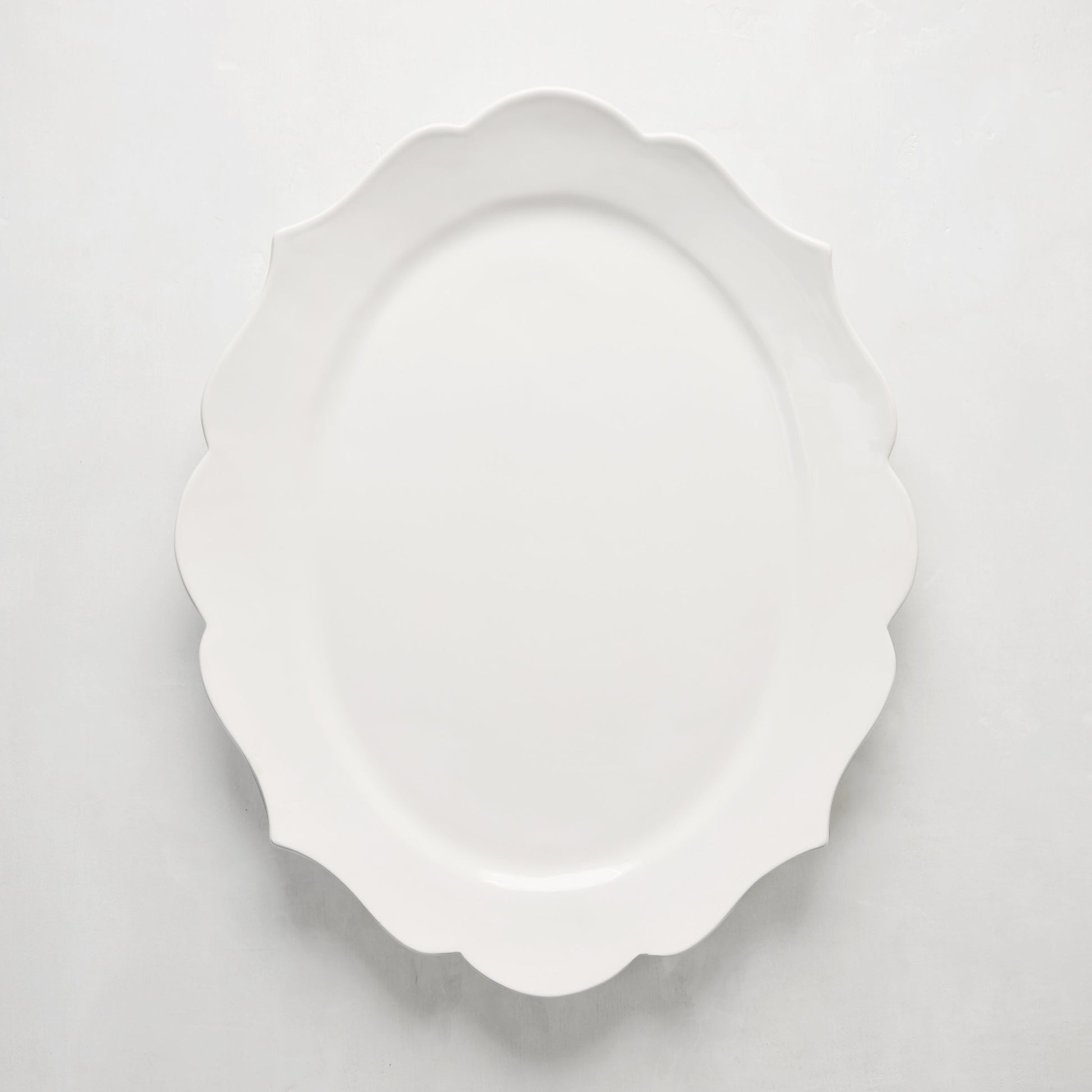 White ceramic Lungarno serving platter with sculptural, scalloped edges.