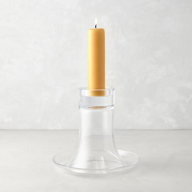 Medium Luz clear glass candleholder with a lit amber pillar candle.