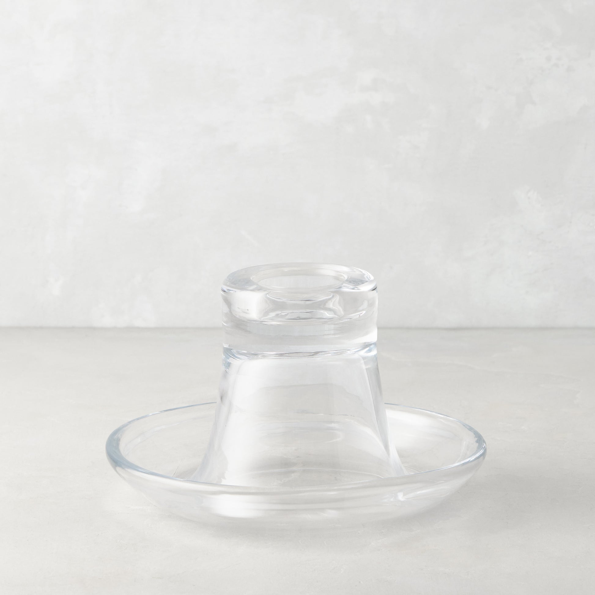Clear glass Luz Candleholder Small, mouth-blown, with a wide base and narrow top, on a light background.