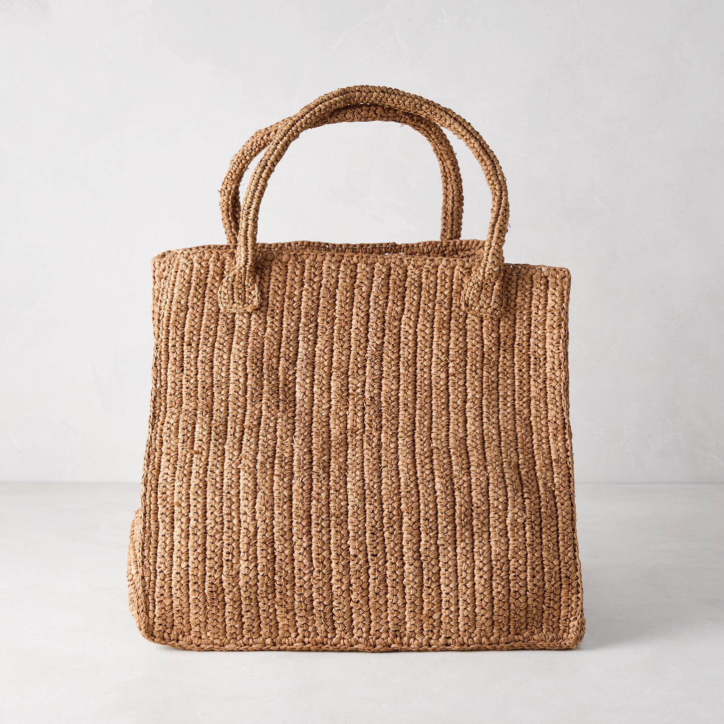 Handcrafted Madagascar Packable Raffia Tote Bag, tea-dyed, with crocheted texture and two top handles.