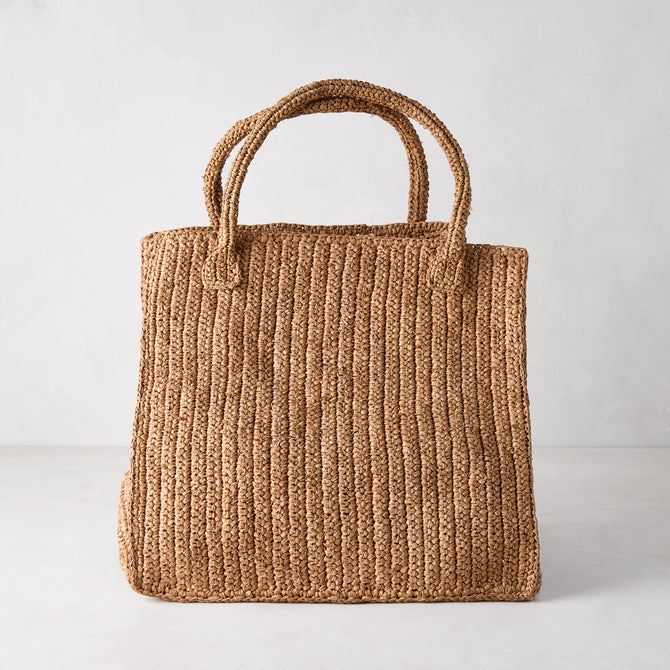 Handcrafted Madagascar Packable Raffia Tote Bag, tea-dyed, with crocheted texture and two top handles.